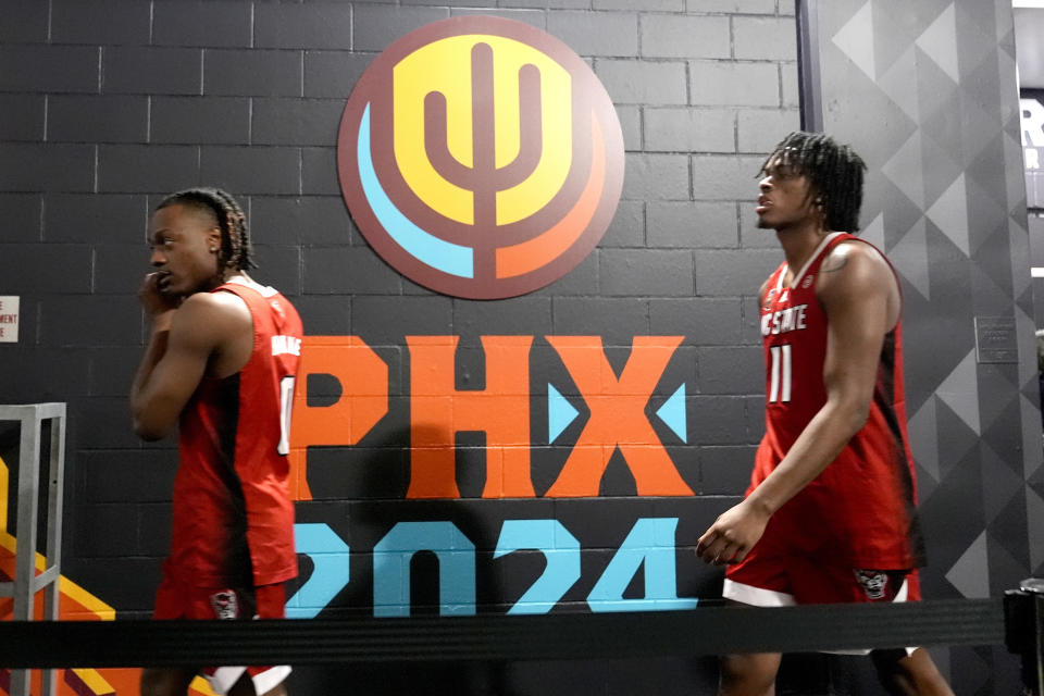 NC State guard DJ Horne, left, and guard Dennis Parker Jr. exit their locker room after a media availability ahead of a Final Four college basketball game in the NCAA Tournament, Thursday, April 4, 2024, in Glendale, Ariz. NC State plays Purdue on Saturday. (AP Photo/Brynn Anderson )
