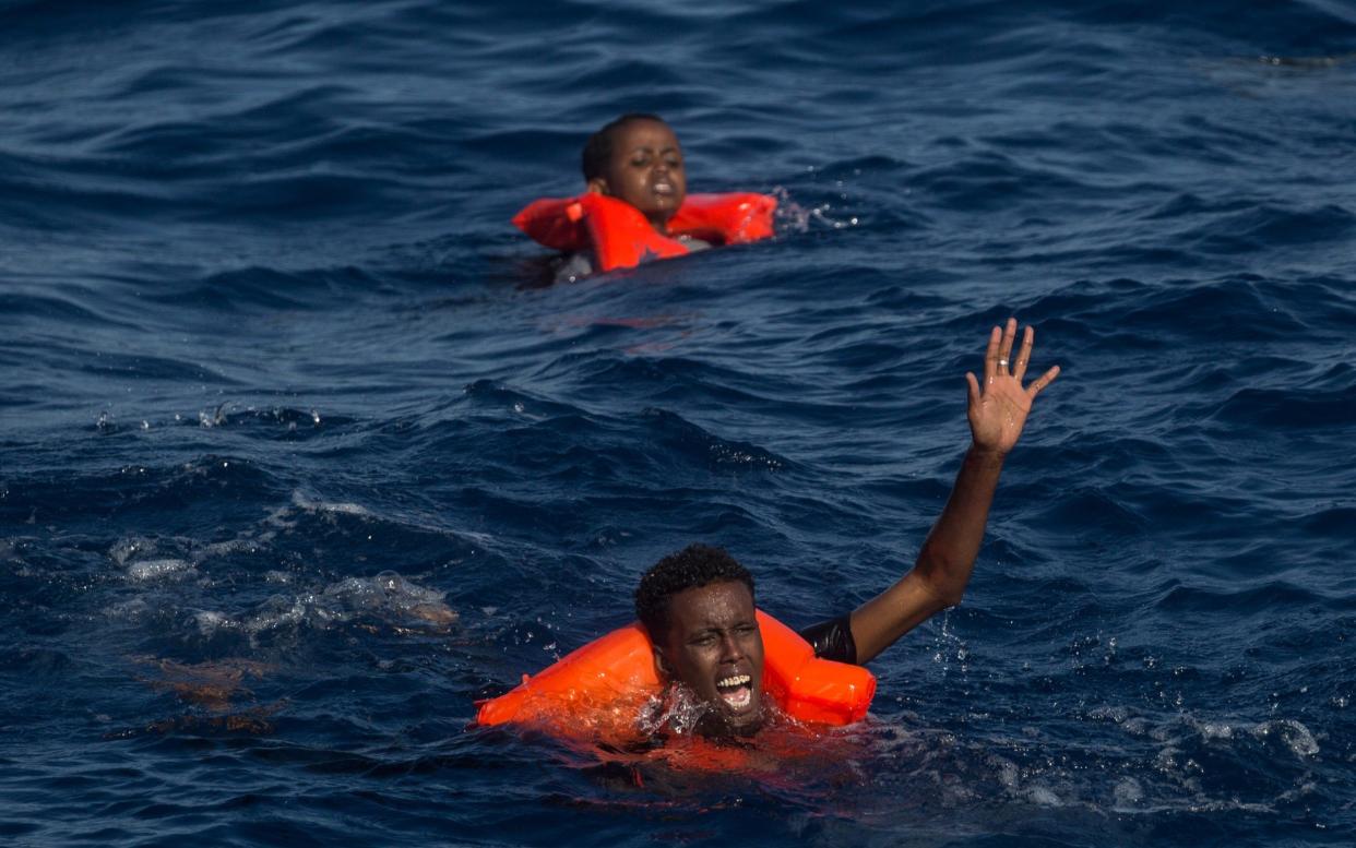 Migrants call for help after a wooden boat bound for Italy carrying more than 500 people capsized  - Getty Images Europe