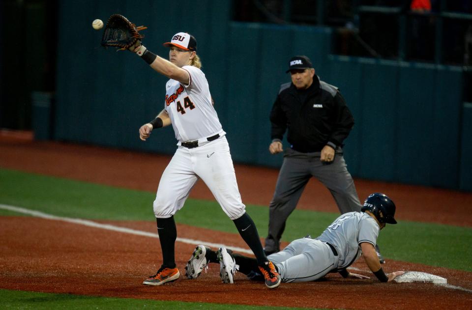 Oregon State first baseman Garret Forrester, left, makes a catch as New Mexico State second baseman Edwin Martinez-Pagani slides safely back to first base during the 2022 NCAA Corvallis Regional at Goss Stadium Friday, June 3, 2022, in Corvallis.