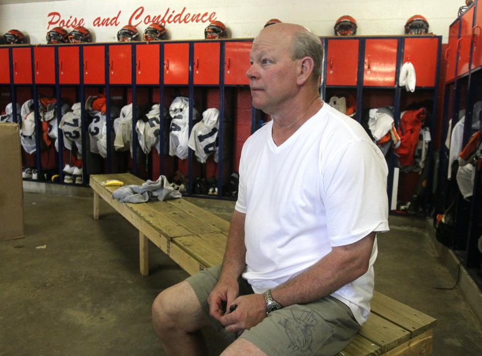 Ellet High football coach Joe Yost sits in a meeting with players and the coaching staff between practice sessions on Aug. 13, 2013.