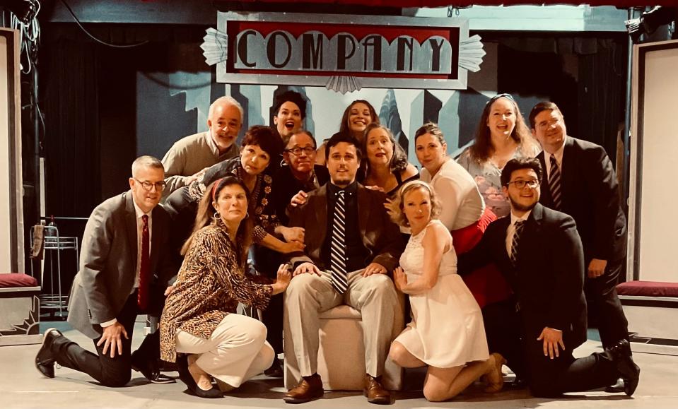 The cast of Stephen Sondheim's "Company," on stage at Eventide Theatre Company in Dennis. Center seated: Zack Johnson as commitment-phobic leading man Bobby. Front kneeling: Ken Holland as David, Meg Morris as Sarah, Rebecca Riley as Amy, Max Dexter as Paul. Second row: Lynne Ruberti Johnson as Jenny, John Weltman as Larry, Kathleen Larson Day as Joanne, Laura Shea Holland as Susan. Back Row: Mike Good as Harry, Sarah Bleything as April, Morgan Dexter as Marta, Martha Paquin as Kathy, Kevin Kennelly as Peter.