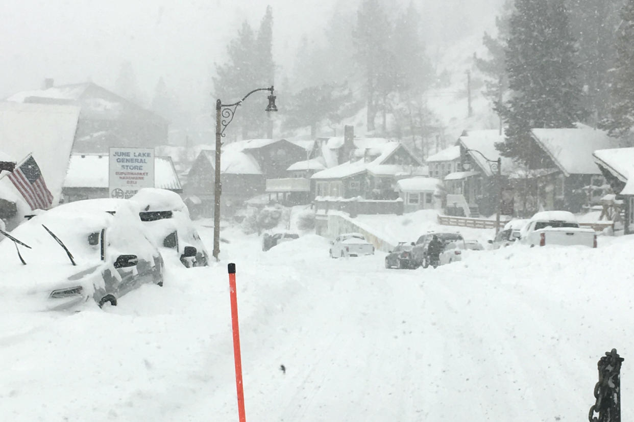 In this photo provided by Caltrans District 9, heavy snowfall blankets car at June Lake, in Mono County on Wednesday, Jan. 27, 2021. An atmospheric river storm pumped drenching rains into the heart of California on Thursday as blizzard conditions buried the Sierra Nevada in snow. (Randy Walker/Caltrans District 9 via AP)