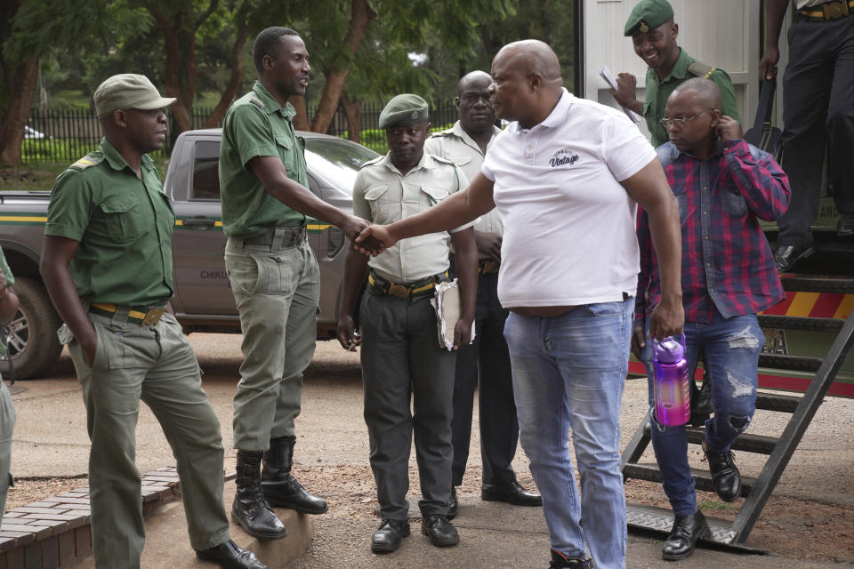 Zimbabwean opposition figure Job Sikhala greets prison officers upon his arrival at the magistrates courts in Harare, Wednesday, Jan, 24. 2024. A Zimbabwean court is expected to give judgment Wednesday on Sikhala who spent nearly two years in pretrial detention on political charges. (AP Photo/Tsvangirayi Mukwazhi)