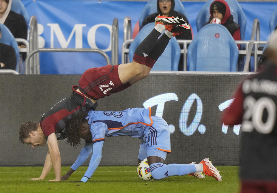 Toronto FC defender Sigurd Rosted (17) falls over New York City FC forward Malachi Jones (88) during the first half of an MLS soccer match Saturday, May 11, 2024, in Toronto. (Frank Gunn/The Canadian Press via AP)