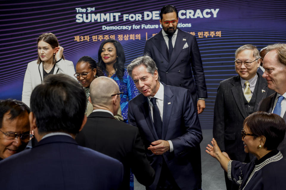 U.S. Secretary of State Antony Blinken, center, shakes hands with an attendee as they take part in a family photo session at the third Summit for Democracy in Seoul, South Korea, March 18, 2024. (Evelyn Hockstein/Pool Photo via AP)