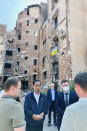 In this photo released by the Press and Media Bureau of the Indonesian Presidential Palace, Indonesian President Joko Widodo, center, talks to residents near an apartment building damaged by shelling, during his visit in the town of Irpin on the outskirts of Kyiv, Ukraine on Wednesday, June 29, 2022. (Laily Rachev, Indonesian Presidential Palace via AP)