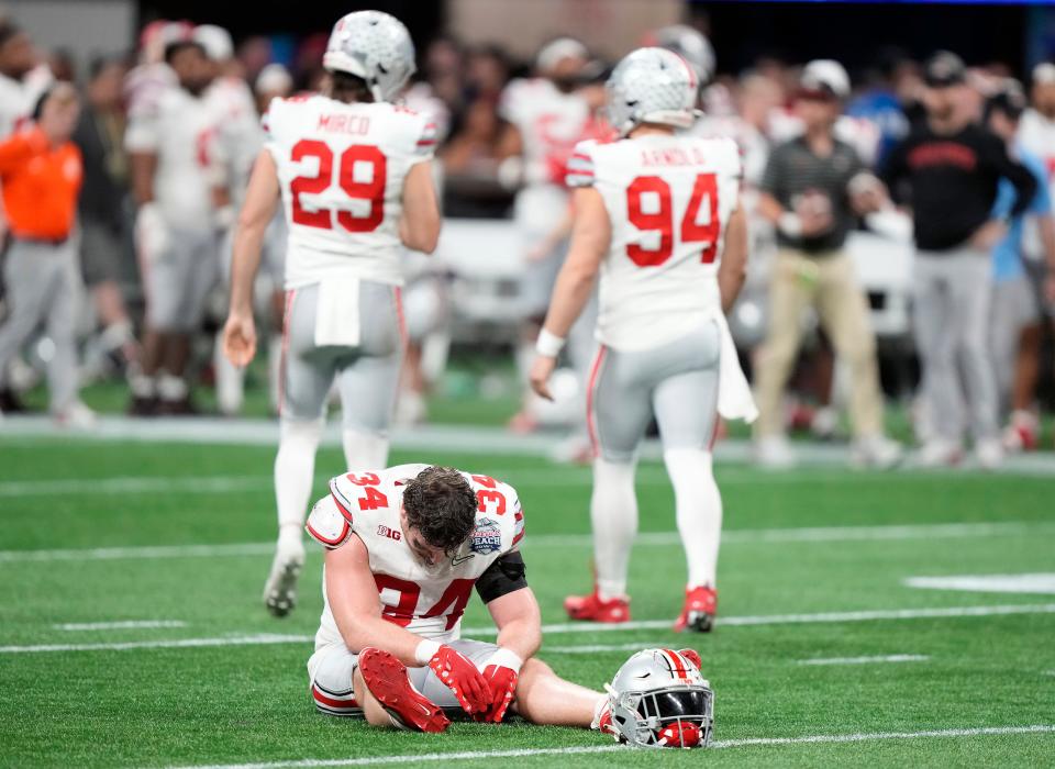 Dec 31, 2022; Atlanta, Georgia, USA; Ohio State Buckeyes tight end Mitch Rossi (34) sits on the ground after Ohio State Buckeyes place kicker Noah Ruggles (95) missed the game winning field goal during the fourth quarter of the Peach Bowl in the College Football Playoff semifinal at Mercedes-Benz Stadium. 