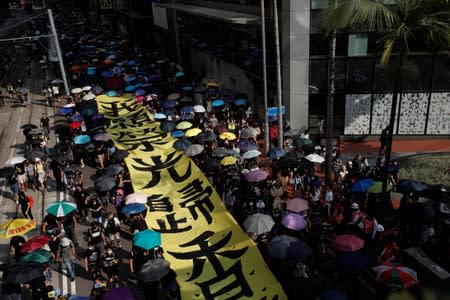 Anti-government protesters wearing masks march during a protest in central Hong Kong