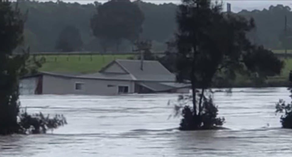 The couple's house is seen floating in the flooded Manning River in Taree.