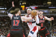 Washington Wizards' Corey Kispert (24) is fouled by Chicago Bulls' Onuralp Bitim (17) as Alex Caruso also defends during the first half of an NBA basketball game Monday, March 25, 2024, in Chicago. (AP Photo/Charles Rex Arbogast)