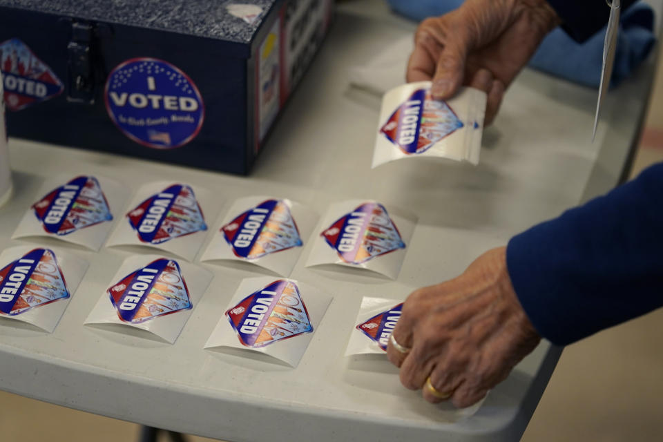 A pole worker lays out "I Voted" stickers at a polling place Tuesday, June 14, 2022, in Las Vegas. (AP Photo/John Locher)