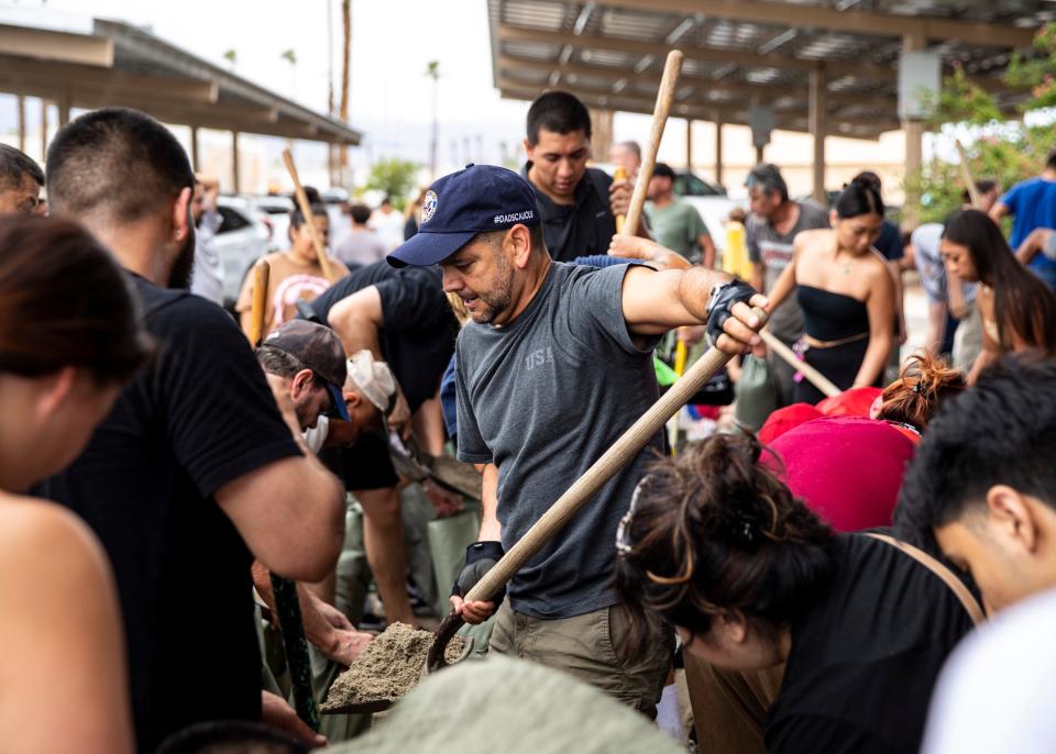 U.S. Rep. Raul Ruiz helps residents fill their sandbags to prepare for hurricane Hilary at city hall in Indio, Calif., Saturday, Aug. 19, 2023. 