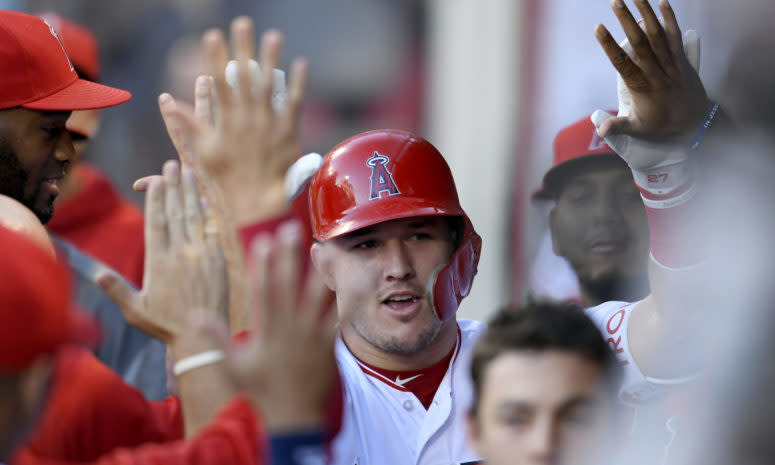 Mike Trout celebrating with his teammates in the dugout.
