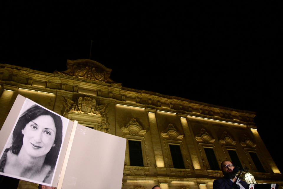 A protester holds up a picture of murdered reporter Daphne Caruana Galizia on the second day of a demonstration outside Malta's prime minister's office in Valletta, Malta, early Tuesday, Nov. 26, 2019. On Wednesday, Nov. 27, 2019 Maltese police arrested Prime Minister Joseph Muscat’s former chief of staff Keith Schembri for questioning as a person of interest in the murder of the journalist. (AP Photo/Str)