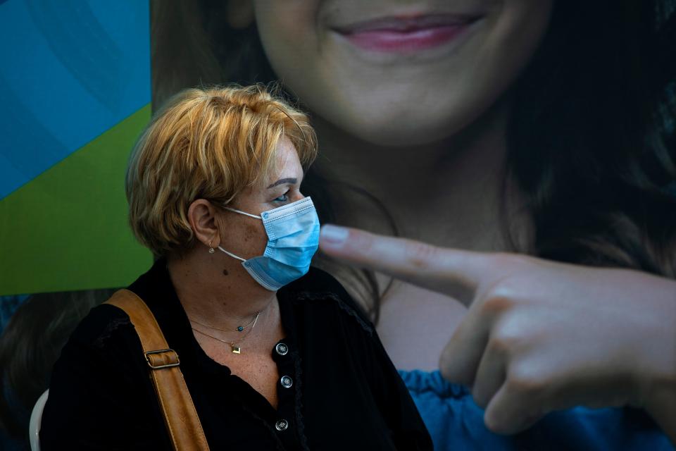 A woman rests after receiving a third Pfizer-BioNTech COVID-19 vaccine at a coronavirus vaccination center in Tel Aviv, Israel, Tuesday, Aug. 10, 2021. Israel is grappling with a surge of infections and urging people over age 60 to get a booster shot. 