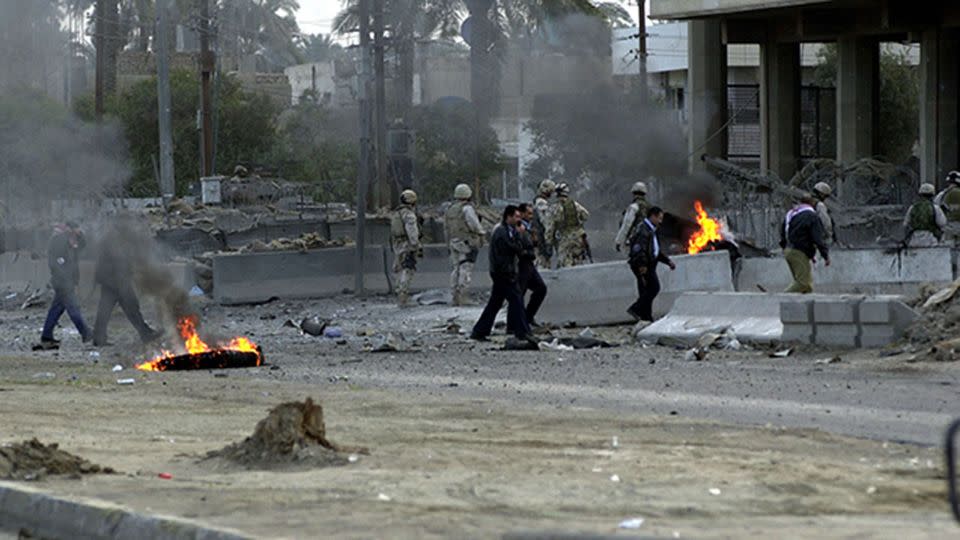 US soldiers and an Iraqi policeman are at the scene of a 2005 car bombing in Baghdad located near the Australian Embassy. Photo: AP/Mohammed Uraibi