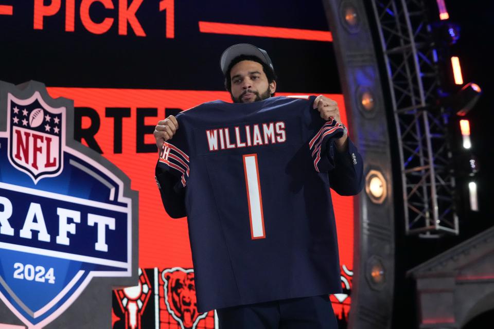Southern California Trojans quarterback Caleb Williams holds up his jersey after being selected by the Chicago Bears as the No. 1 pick in the first round of the 2024 NFL Draft at Campus Martius Park and Hart Plaza.