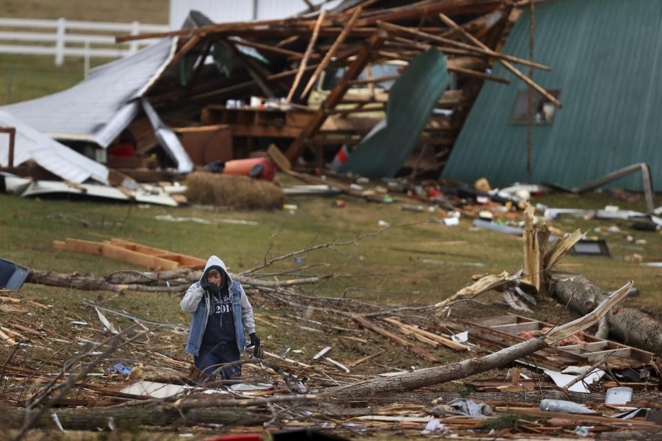 Image: A woman searches for valuables amidst the remnants of a home on Dec. 11, 2021 on Highway F in Defiance, Mo. (Christian Gooden / St. Louis Post-Dispatch via AP)