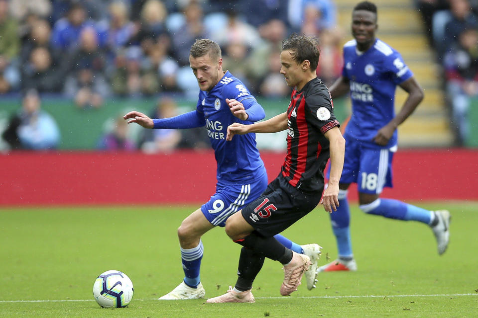 Leicester City's Jamie Vardy, left, and Huddersfield Town's Chris Lowe during their English Premier League soccer match at the King Power Stadium in Leicester, England, Saturday Sept. 22, 2018. (Nigel French/PA via AP)