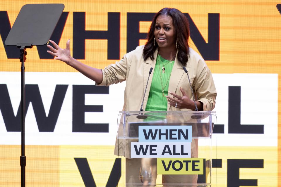 Michelle Obama speaks onstage in a green top