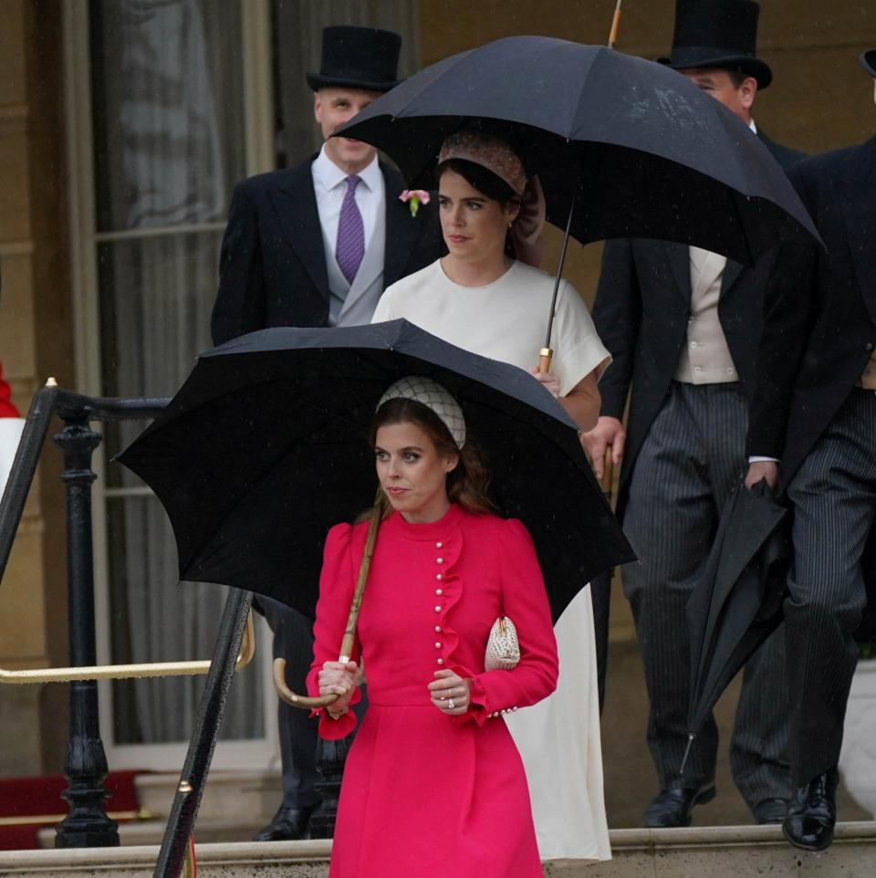 Princesses Beatrice and Eugenie descend the stairs to join the party