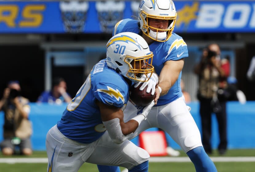 INGLEWOOD, CA - OCTOBER 10, 2021: Los Angeles Chargers quarterback Justin Herbert (10) hands off to Los Angeles Chargers running back Austin Ekeler (30) against the Cleveland Browns in the first half at SoFi Stadium on October 10, 2021 in Inglewood, California. Ekeler finished with 119 yards rushing and three touchdowns in the Chargers 47-42 win.(Gina Ferazzi / Los Angeles Times)