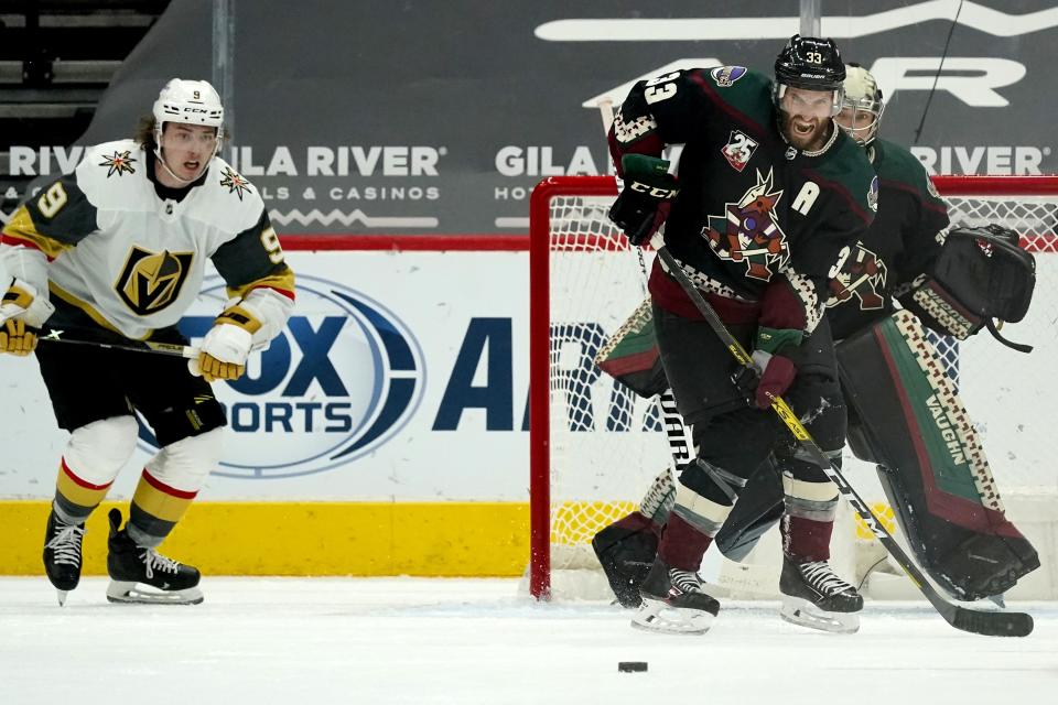 Arizona Coyotes defenseman Alex Goligoski (33) reacts as he watches the puck in front of Coyotes goaltender Darcy Kuemper, right, as Vegas Golden Knights center Cody Glass (9) moves in just prior to his shot for a goal during the third period of an NHL hockey game Friday, Jan. 22, 2021, in Glendale, Ariz. (AP Photo/Ross D. Franklin)