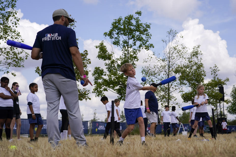 A kid hits a baseball during the MLB First Pitch Festival, at the Queen Elizabeth Olympic Park, in London, Thursday, June 22, 2023. Britain's relative success at the World Baseball Classic and the upcoming series between the Chicago Cubs and St. Louis Cardinals has increased London's interest about baseball. The sport's governing body says it has seen an uptick in interest among kids. (AP Photo/Alberto Pezzali)