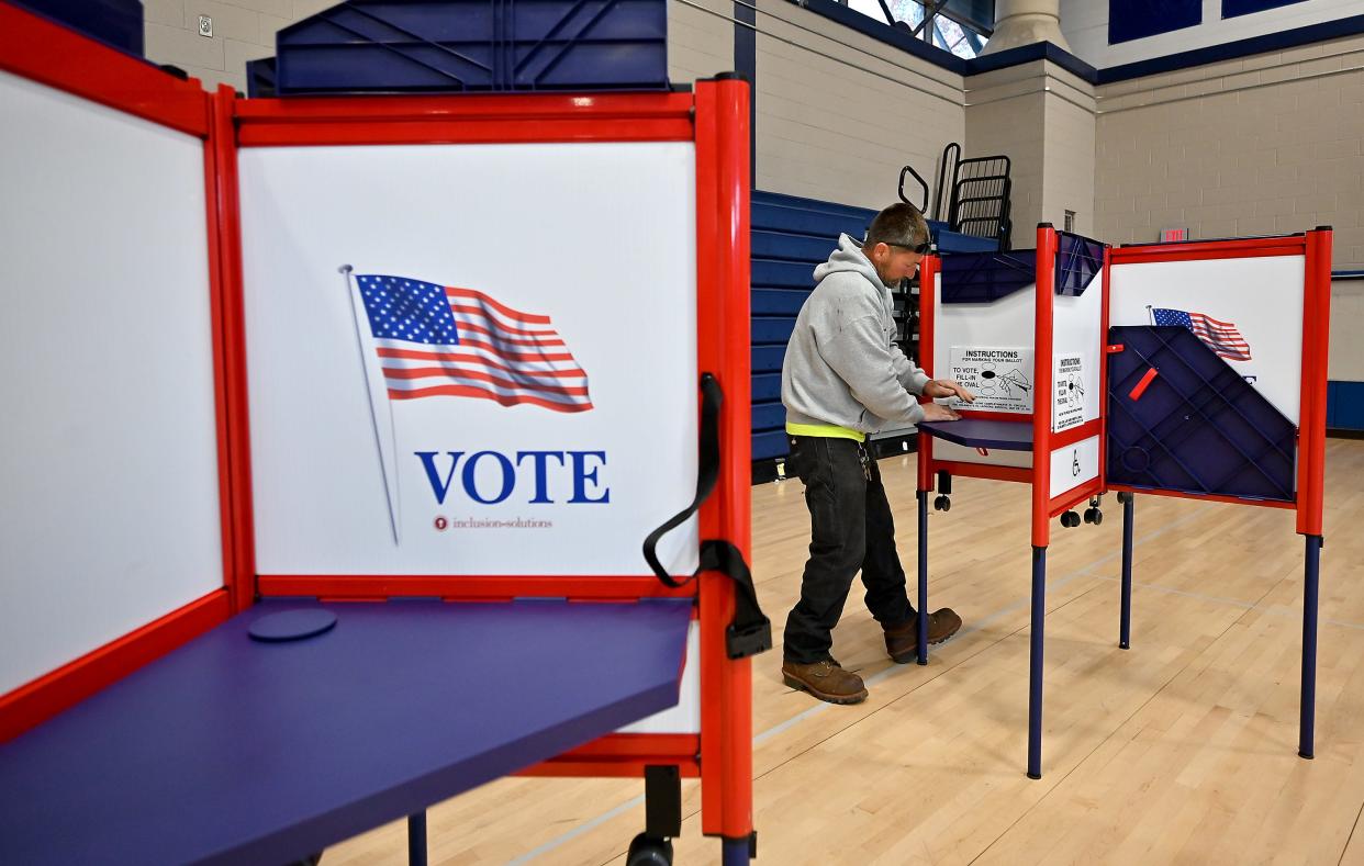 Parks Department foreman Mark Rainey sets up new voting booths at Worcester Technical High School.