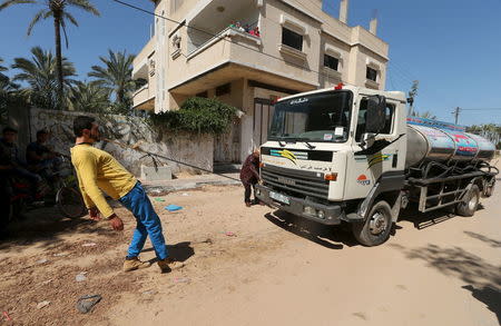 Palestinian Mohammad Baraka, 20, nicknamed by people as Gaza Samson, pulls a water tanker by a rope attached to his teeth as he exercises in Deir al-Balah in the central Gaza Strip March 5, 2016. REUTERS/Mohammed Salem