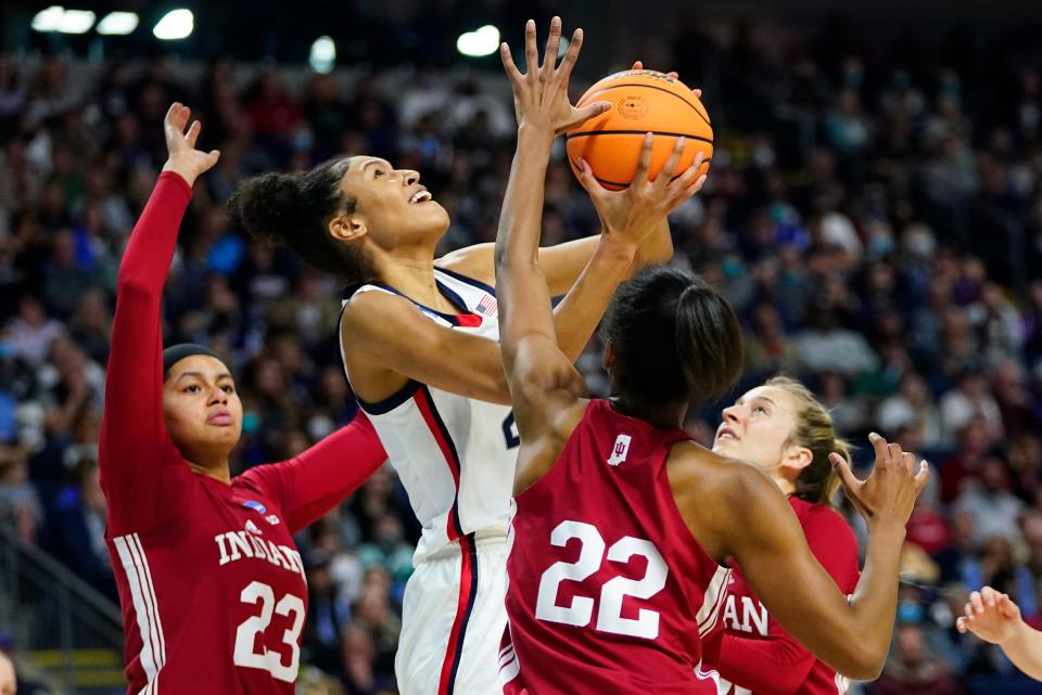 Connecticut forward Olivia Nelson-Ododa (20) puts up a shot against Indiana guard Chloe Moore-McNeil (22), forward Kiandra Browne (23) and guard Nicole Cardano-Hillary (4) during the first quarter of a college basketball game in the Sweet Sixteen round of the NCAA women's tournament, Saturday, March 26, 2022, in Bridgeport, Conn. (AP Photo/Frank Franklin II)