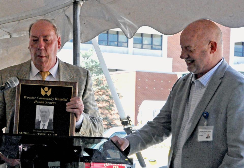 Bob Reynolds, Wooster mayor and hospital board member, presents soon-to-retire hospital CEO Bill Sheron with a plaque honoring his 30 years of service to the hospital.