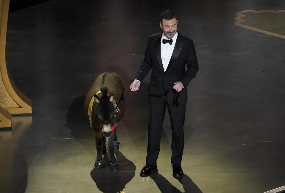 Jimmy Kimmel walks onstage with Jenny, the miniature emotional support donkey, at the Oscars on Sunday, March 12, 2023, at the Dolby Theatre in Los Angeles. (AP Photo/Chris Pizzello)
