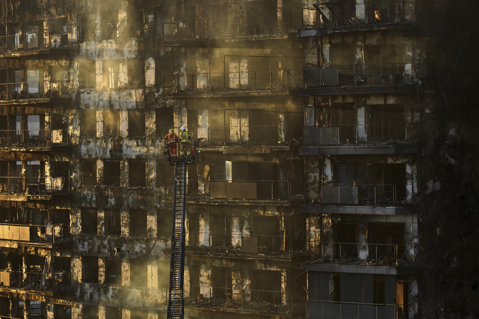 Firefighters work at a burned block building in Valencia, Spain, Friday, Feb. 23, 2024. A fire has engulfed two residential buildings in the eastern Spanish city of Valencia, killing at least four people and injuring at least 13 others. Emergency services reported that at least 19 people were still missing several hours after the fire started. (AP Photo/Alberto Saiz)