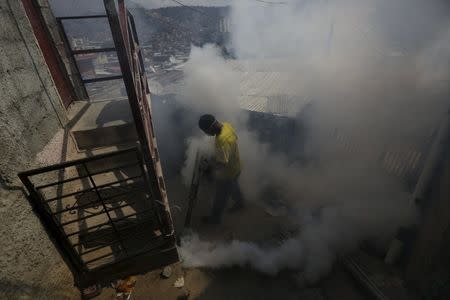 A municipal worker fumigates the Petare slum to help control the spread of the mosquito-borne Zika virus in Caracas, February 3, 2016. REUTERS/Marco Bello