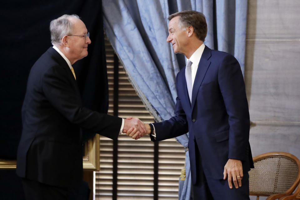 U.S. Sen. Lamar Alexander, R-Tenn., left, shakes hands with Tennessee Gov. Bill Haslam before the unveiling of Haslam's official portrait Monday, Dec. 17, 2018, in Nashville, Tenn. Alexander said Monday he is not running for re-election in 2020. (AP Photo/Mark Humphrey)