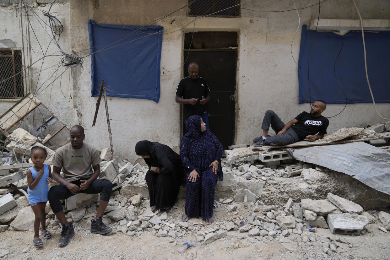 Palestinian refugees sit at the rubble of their partly destroyed house that was damaged during the Israeli army operation in the West Bank refugee camp of Tulkarem, in Tulkarem, Thursday, Sept. 5, 2024. (AP Photo/Nasser Nasser)