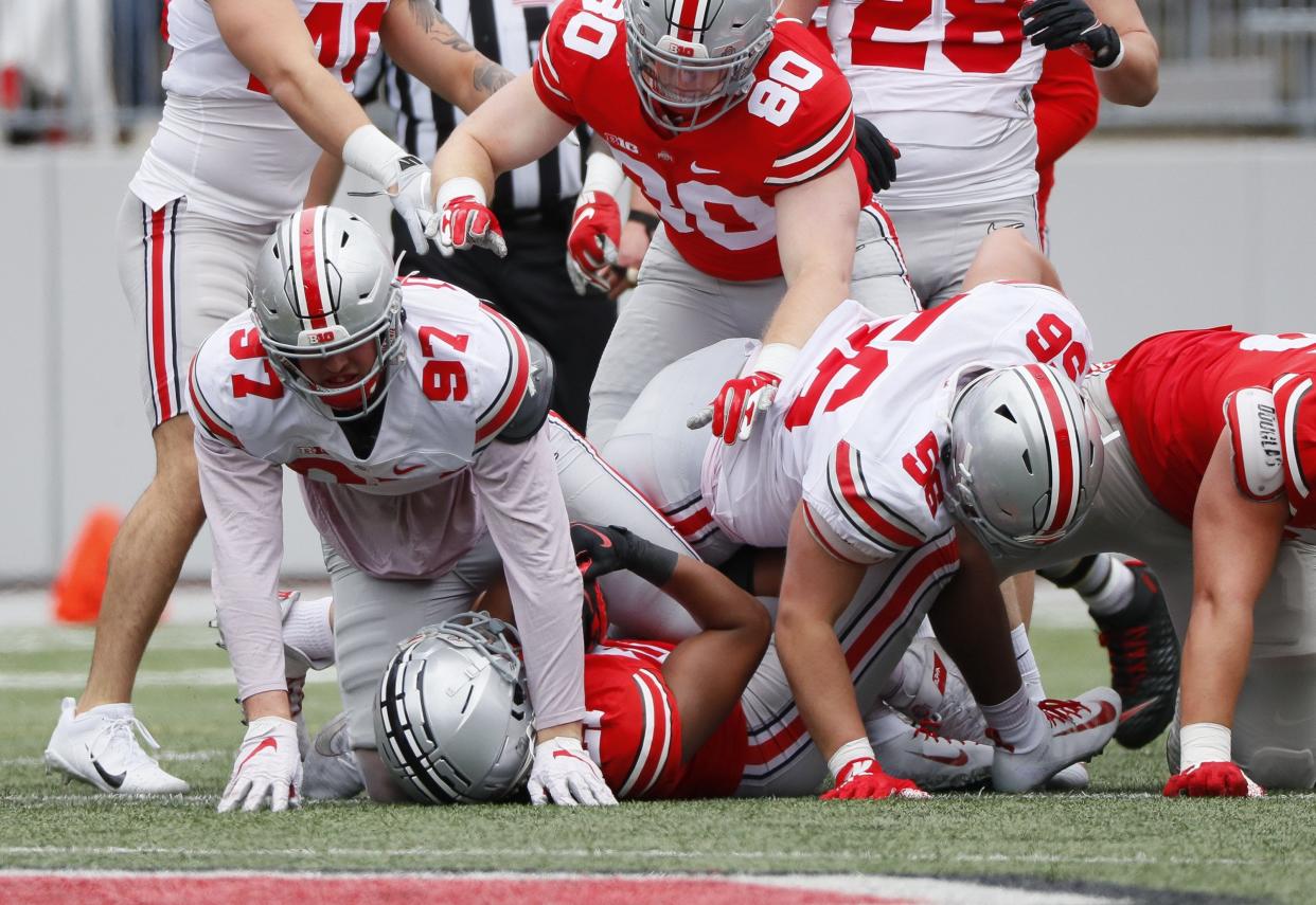 Team Brutus defensive end Noah Potter (97) tackles running back Evan Pryor (21) during the Ohio State Buckeyes football spring game at Ohio Stadium in Columbus on Saturday, April 17, 2021. 