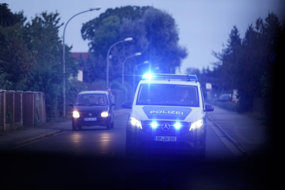 A police car drives with special rights during a patrol to search for migrants crossing illegally the border in Forst southeast of Berlin, Germany, Wednesday, Oct. 11, 2023. (AP Photo/Markus Schreiber)