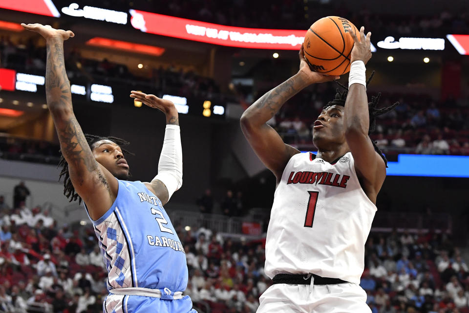 Louisville guard Mike James (1) attempts a shot over North Carolina guard Caleb Love (2) during the second half of an NCAA college basketball game in Louisville, Ky., Saturday, Jan. 14, 2023. North Carolina won 80-59. (AP Photo/Timothy D. Easley)