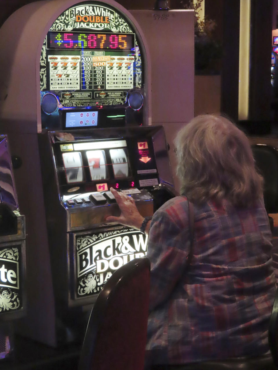 A gambler plays a slot machine at Harrah's casino in Atlantic City N.J., on Sept. 29, 2023. Figures released by New Jersey gambling regulators on April 8, 2024, show Atlantic City's nine casinos collectively reported a gross operating profit of $744.7 million in 2023, a decline of 1.6% from 2022. (AP Photo/Wayne Parry)