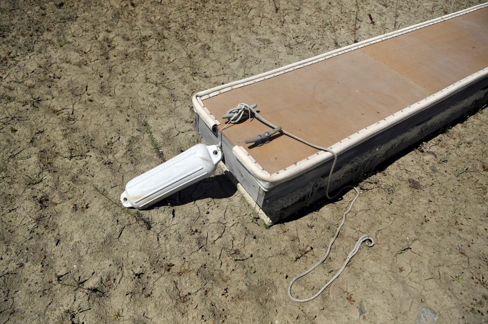 FILE - An empty boat dock sits on dry land at the Browns Ravine Cove area of drought-stricken Folsom Lake, in Folsom, Calif., on May 22, 2021. Months of winter storms have replenished California's key reservoirs after three years of punishing drought. (AP Photo/Josh Edelson, File)