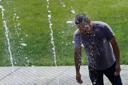 A man cools off in fountain on the Rose Kennedy Greenway during a summer heat wave in Boston, Massachusetts, U.S., July 2, 2018. REUTERS/Brian Snyder