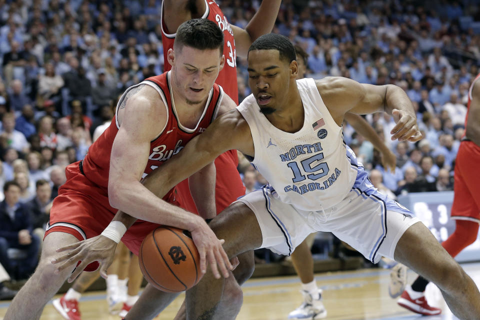 Ohio State forward Kyle Young, left, and North Carolina forward Garrison Brooks (15) reach for the ball during the first half of an NCAA college basketball game in Chapel Hill, N.C., Wednesday, Dec. 4, 2019. (AP Photo/Gerry Broome)