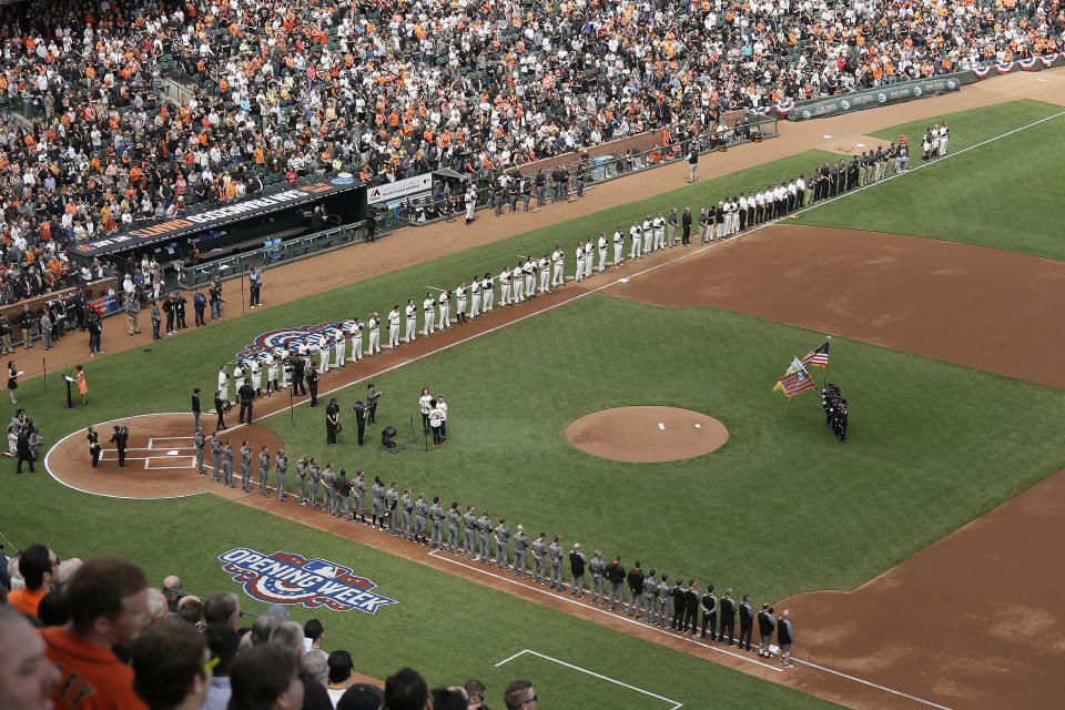 Members from the cast of the musical Hamilton sing the national anthem on opening day as the San Francisco Giants, top, and Arizona Diamondbacks, bottom, line the bases before the start of a baseball game, Monday, April 10, 2017, in San Francisco. (AP Photo/Eric Risberg)