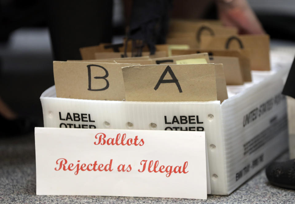 CORRECTS TO REJECTED, NOT ILLEGAL - Rejected mail in ballots sit in a box as members of the canvassing board verify signatures on ballots at the Miami-Dade County Elections Department, Tuesday, Oct. 30, 2018, in Miami. Voters go to the polls in the midterm elections Nov. 6. (AP Photo/Lynne Sladky)