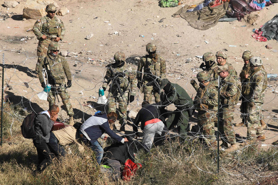 Migrants cross the razor fence placed by elements of the Texas National Guard on the banks of the Rio Grande, in El Paso, Texas, US. border with Ciudad Juarez, Chihuahua state, Mexico, on December 20, 2022. - Title 42, a President Donald Trump pandemic-era law that authorize United States border officials to expel migrants is supposed to end on December 21. (Herika Martinez / AFP - Getty Images)