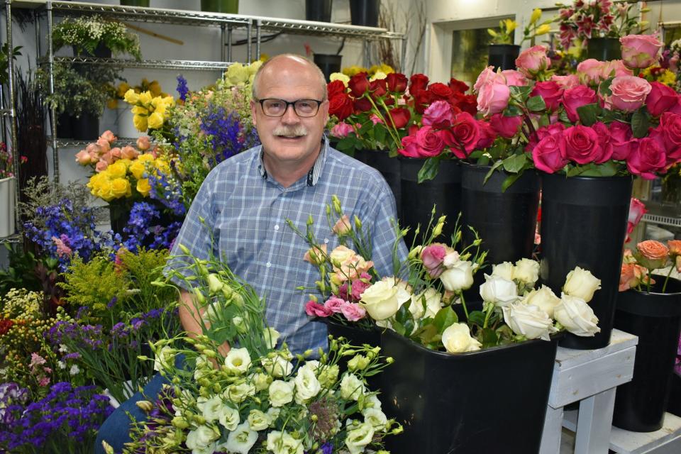 Brian Smith, who owns Everts Flowers with his wife Gina, poses for a photo in the shop's flower cooler.