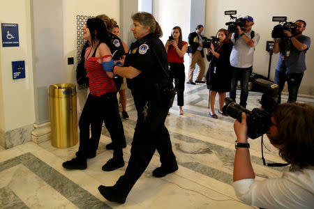 A healthcare activist is detained after a protest to stop the Republican health care bill at Russell Senate Office Building on Capitol Hill. REUTERS/Yuri Gripas