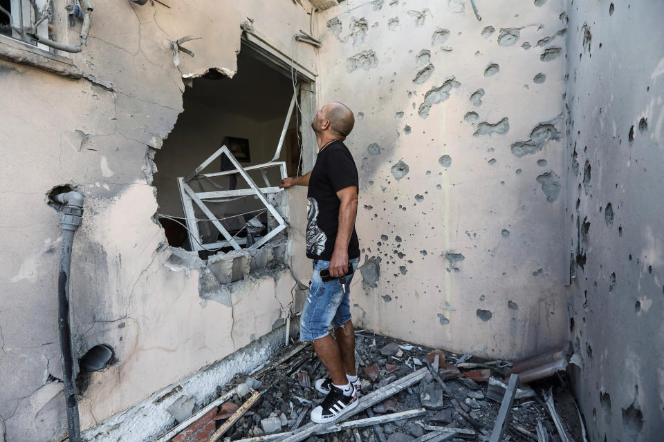 Image: Buchbut looks at his damaged house after it was hit with a rocket fired from Gaza to Sderot, Israel (Baz Ratner / Reuters)